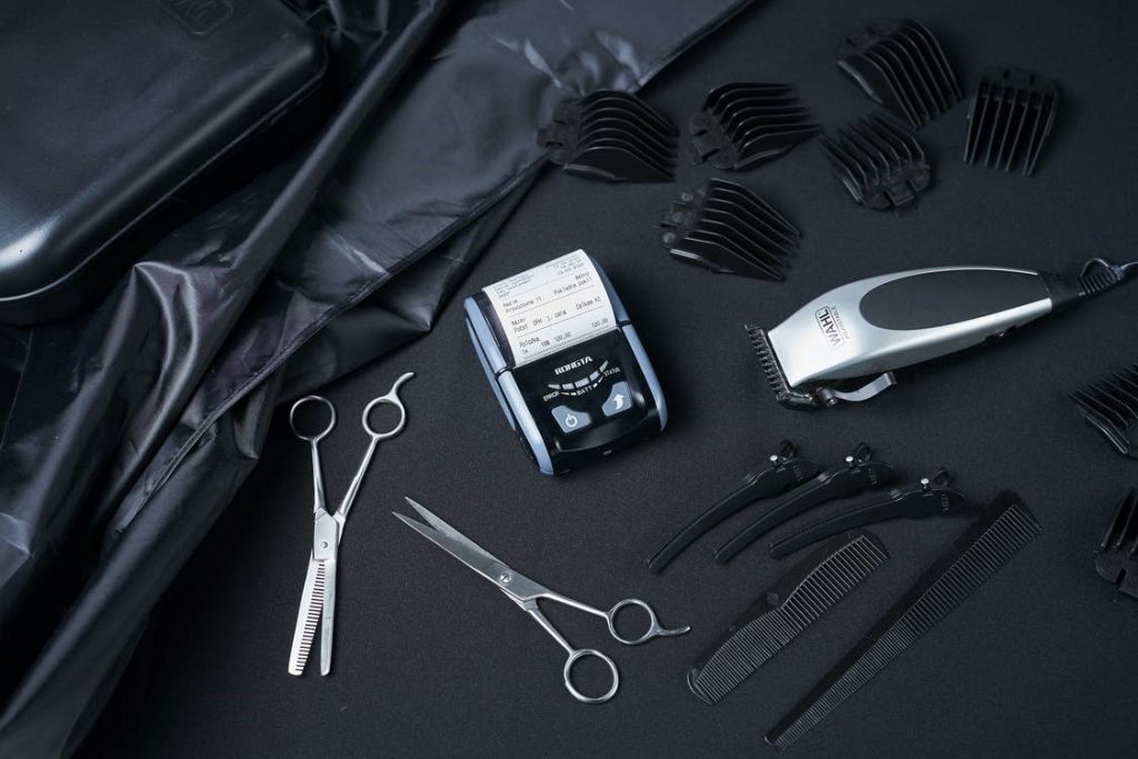 Cash register and haircutting tools on black cloth